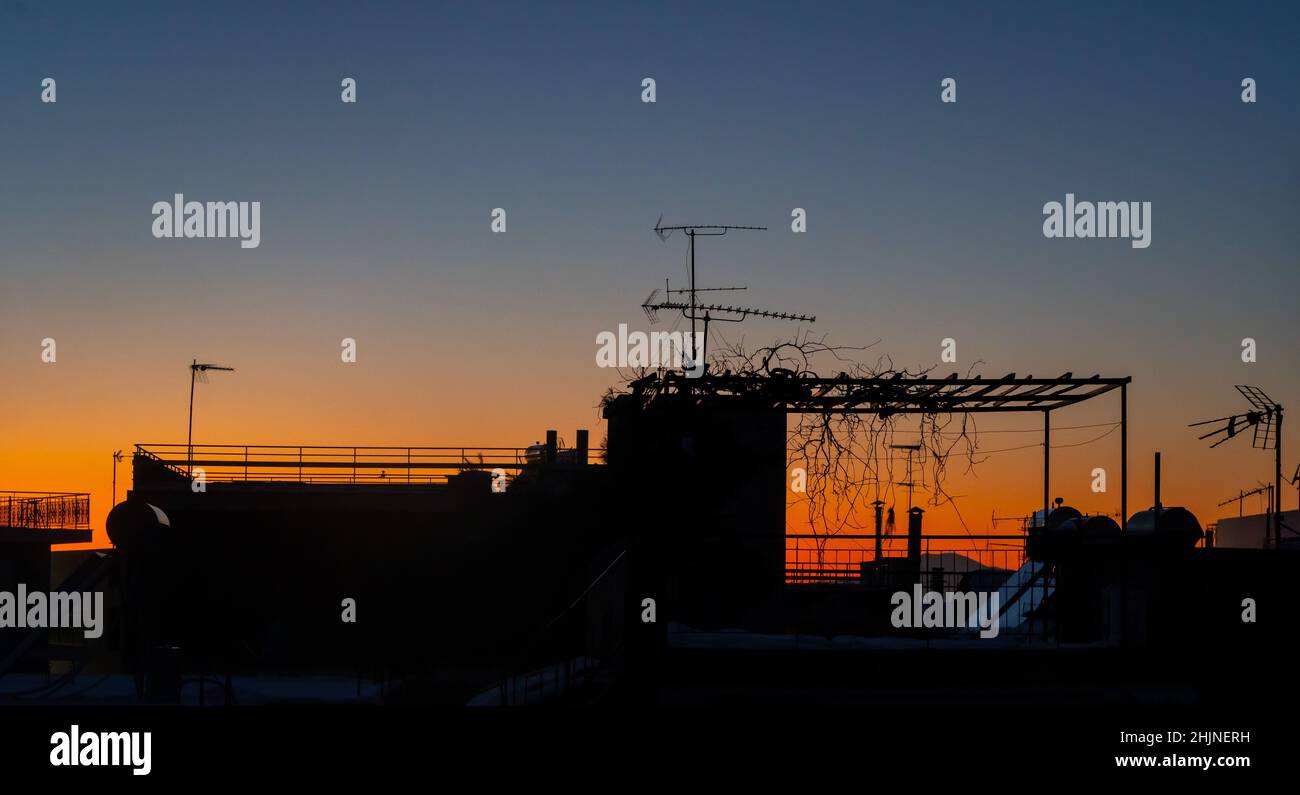 An idyllic sunset looking the naighbor's terrace with its arbor and the solar waterheater Stock Photo