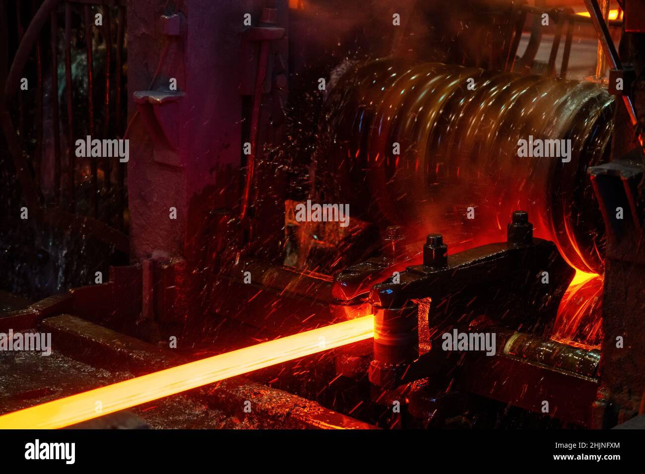 The redhot metal bar is rolled on a rolling mill Stock Photo Alamy