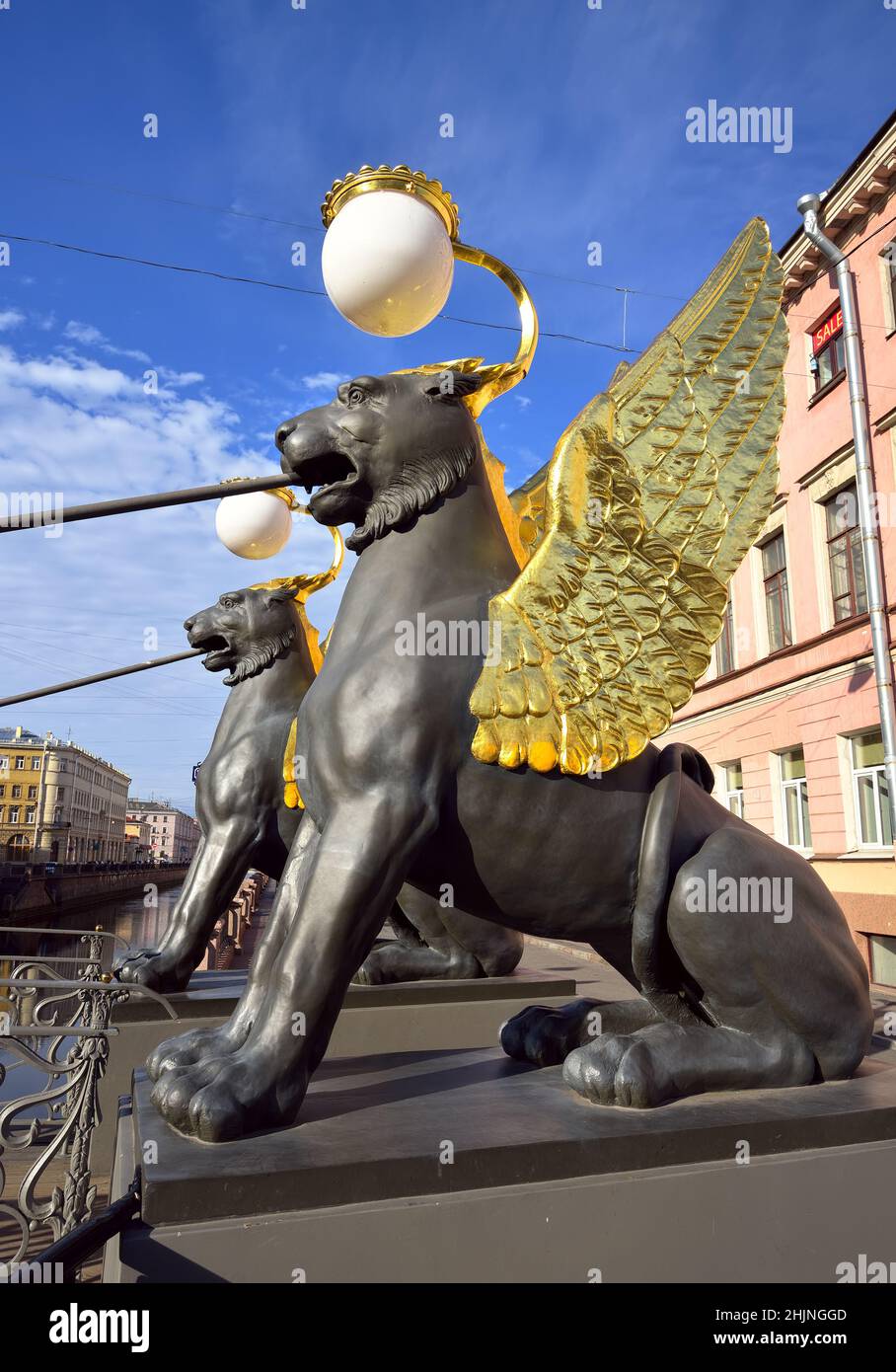 Gryphons of the Bank bridge on the Griboyedov canal. Two sculptures of mythical creatures with Golden wings hold a pedestrian bridge. Art of the XIX c Stock Photo