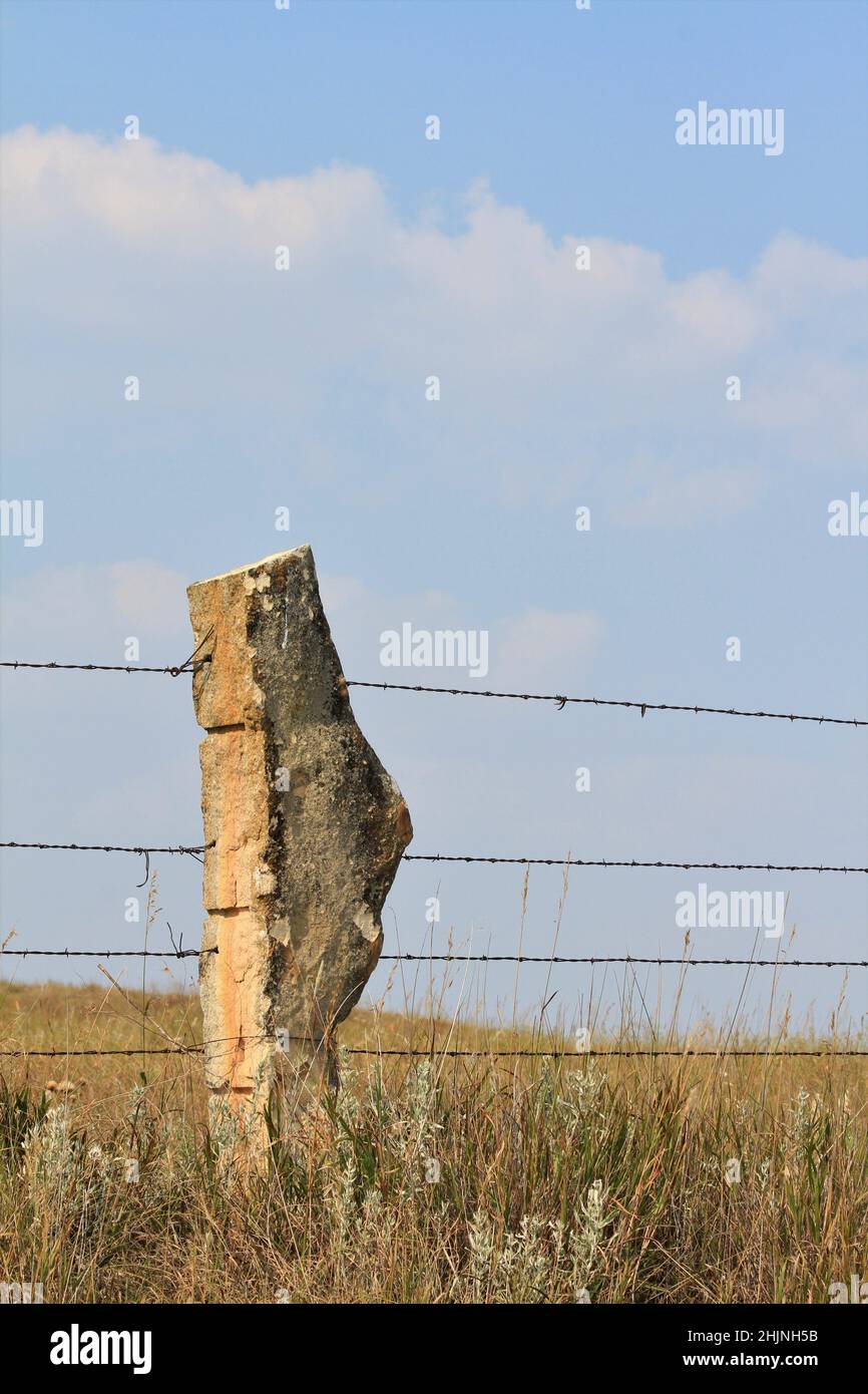 A closeup of a Stone Post fence out in the country with blue sky in Kansas Stock Photo