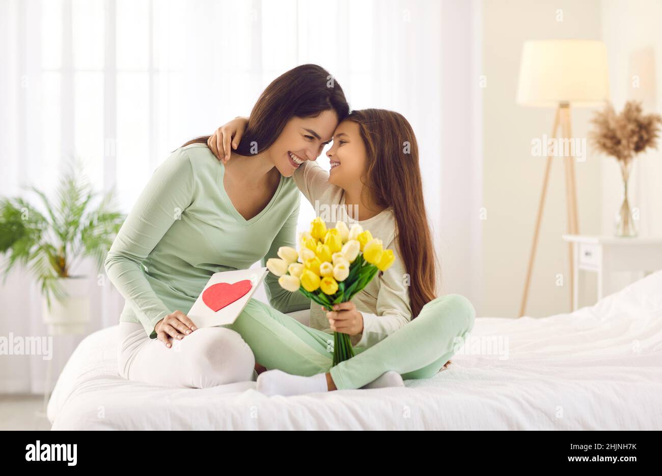 Caring small daughter greeting mom with mothers day Stock Photo