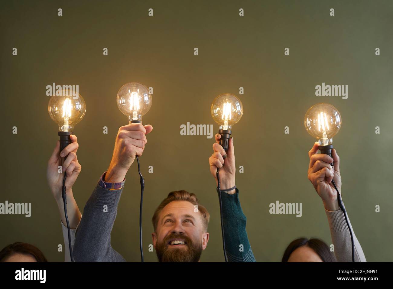 Employees hold lightbulbs develop business ideas Stock Photo