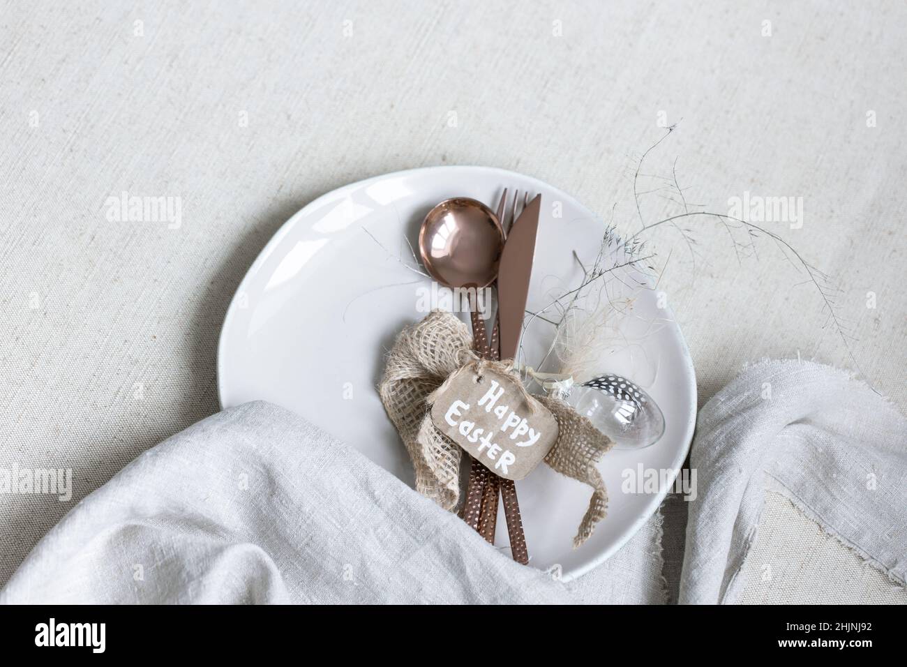 Festive Easter table setting with decor details on white table. Stock Photo