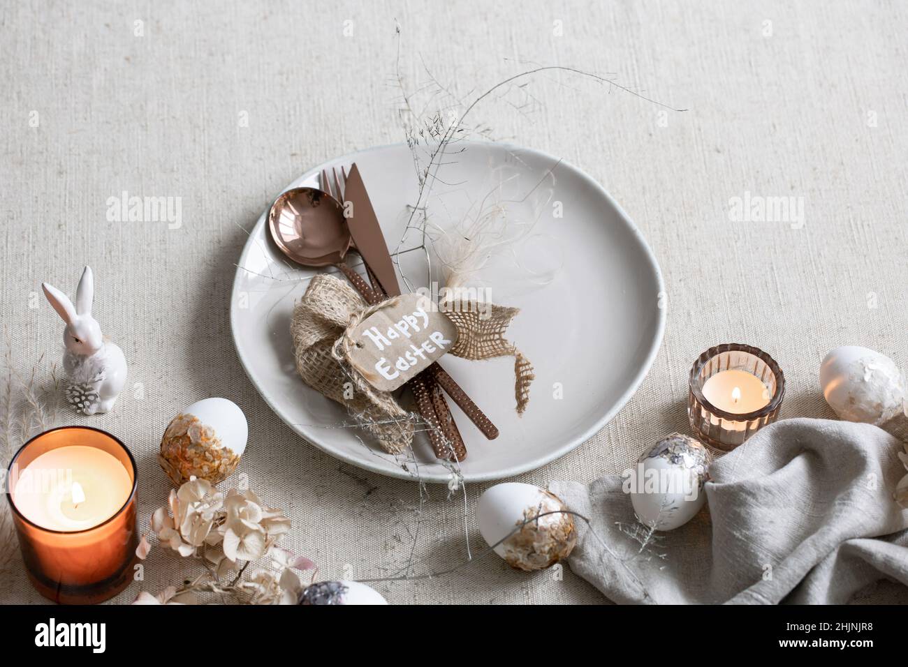 Festive Easter table setting with decor details on white table. Stock Photo