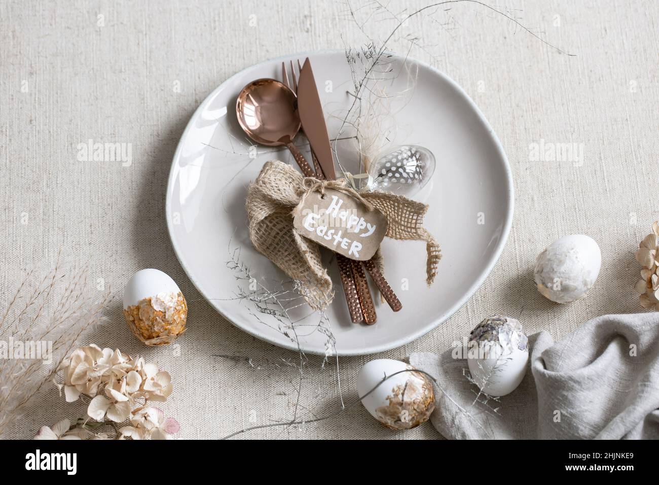 Festive Easter table setting with decor details on white table. Stock Photo