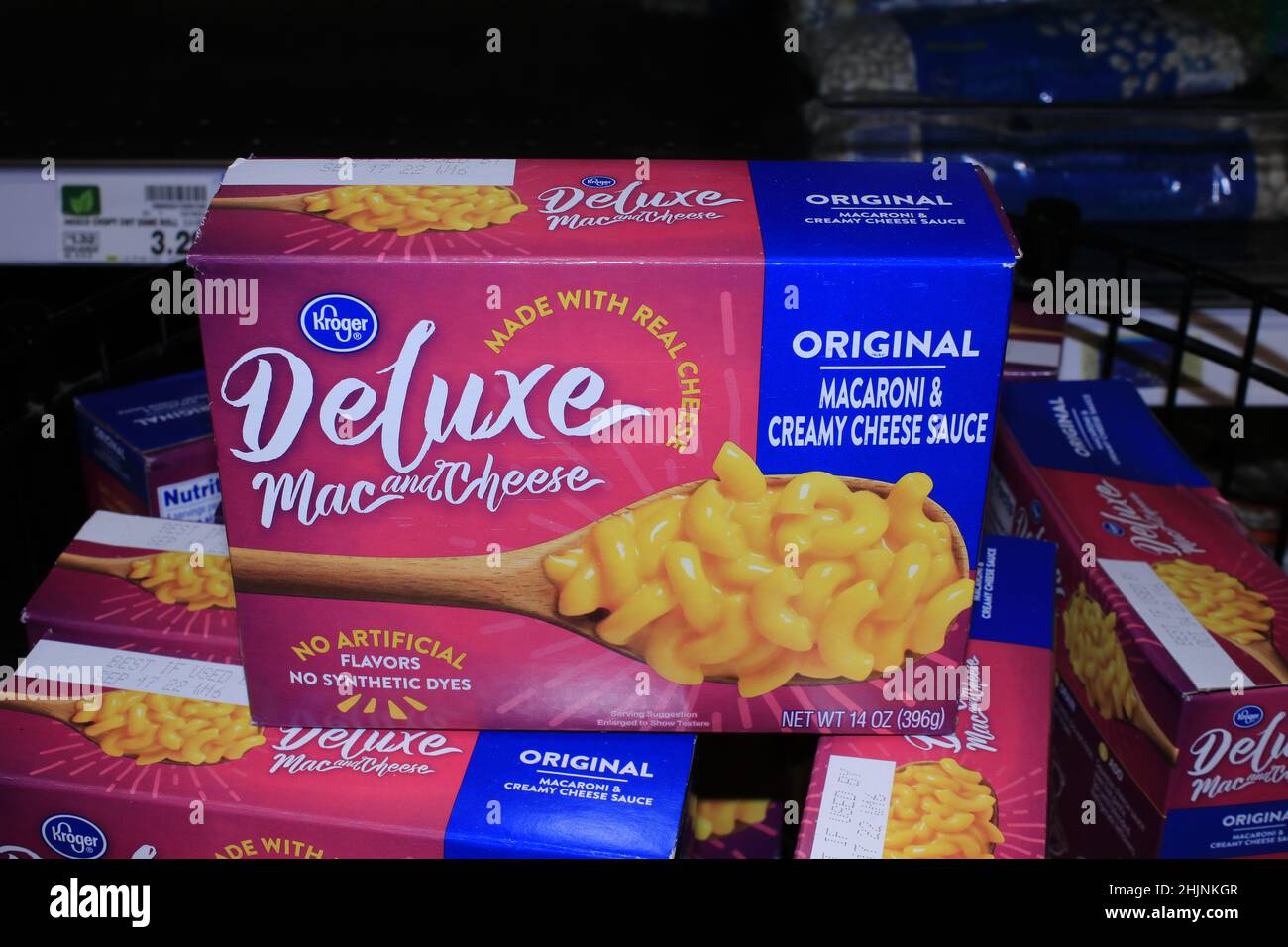 A closeup of Kroger Deluxe Mac and Cheese in a box on a metal shelf at