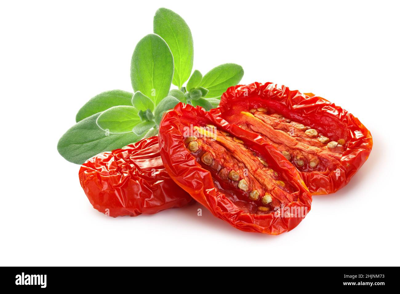 Dried or Sundried tomato halves with marjoram isolated Stock Photo