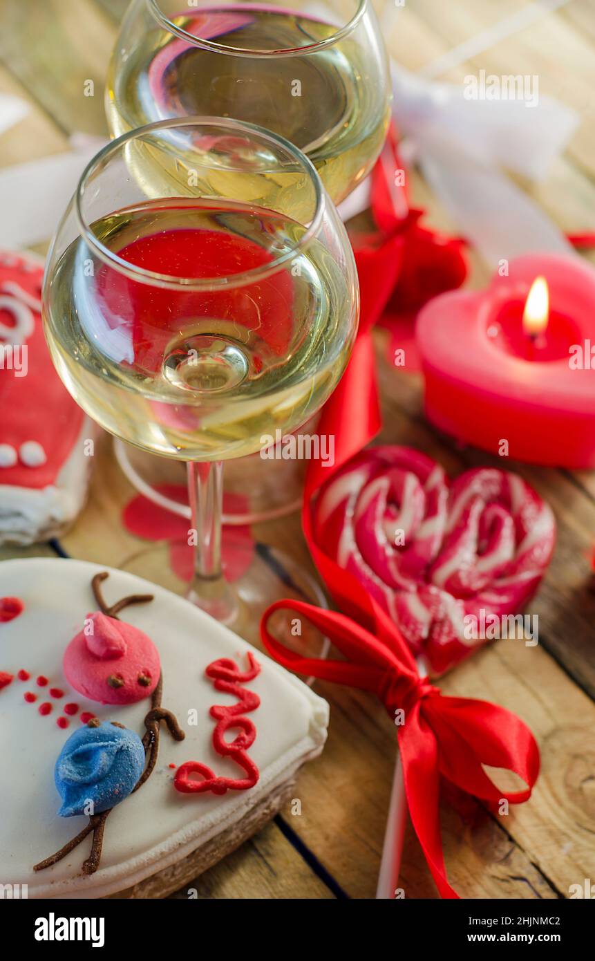 glasses-with-wine-on-the-background-of-sweets-in-the-shape-of-a-heart-2HJNMC2.jpg