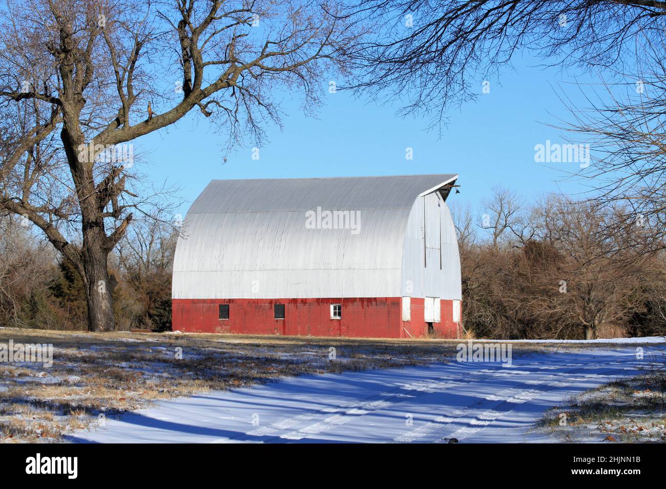 A Red Barn with snow and sky out in the country Stock Photo