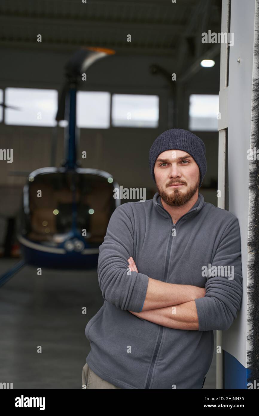 Bearded seriously male looking ahead in hangar Stock Photo
