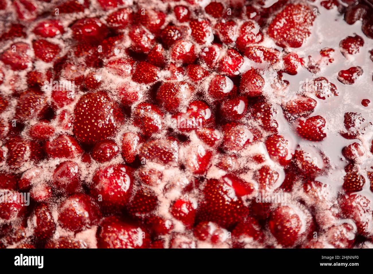 Strawberry jam, top view. Homemade Strawberry jam in making progress boiling. Boiling strawberry jam close up. Strawberry jam is boiling, detailed shooting. Stock Photo