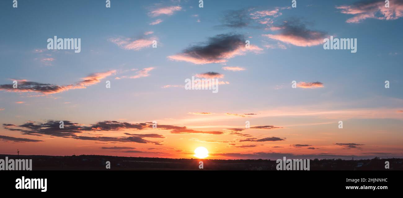 Blue Raspberry Cloud Background sunset panorama with raspberry clouds over a small town against a blue ...