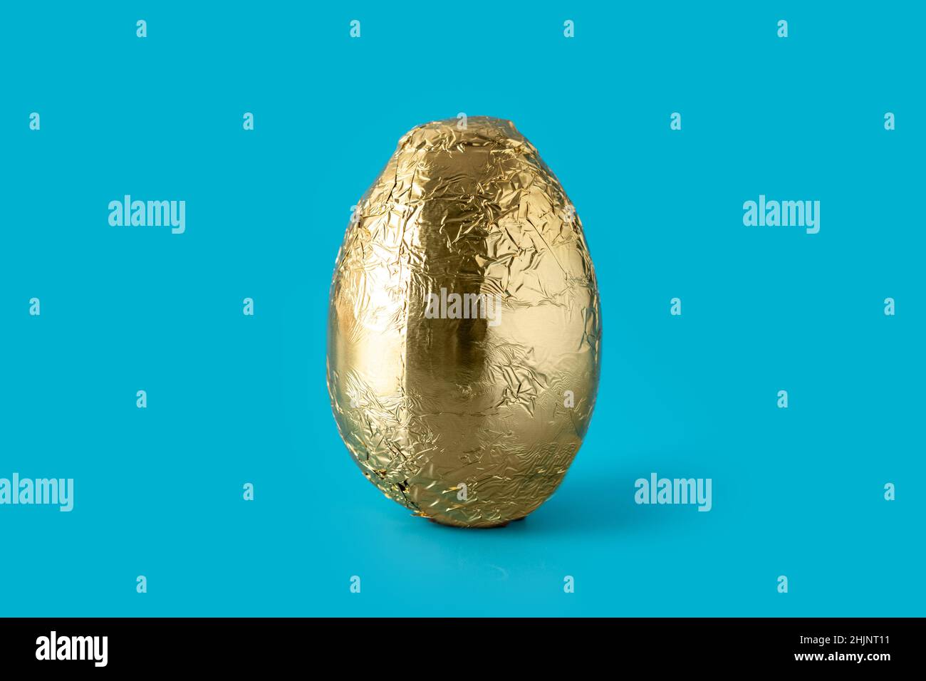Golden Easter egg on blue background Stock Photo