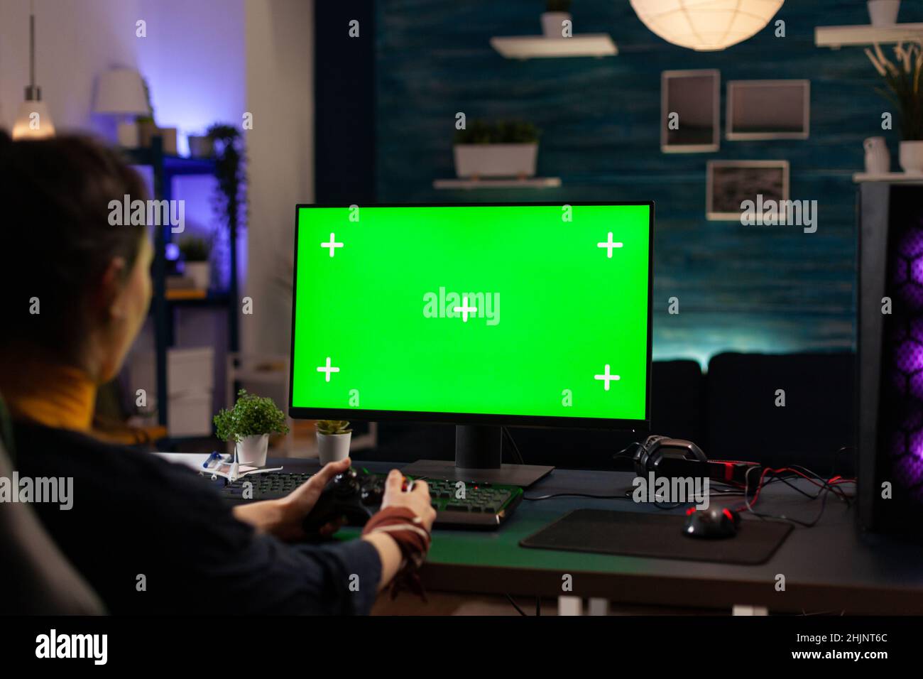 Player using horizontal green screen on computer, playing video games