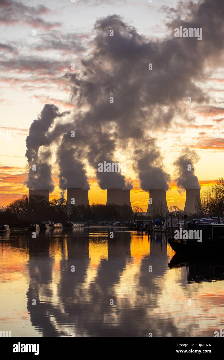Beautiful dawn sunrise coal fired power station cooling towers smoke plumes into sky. Global warming electricity generation stunning reflection river Stock Photo