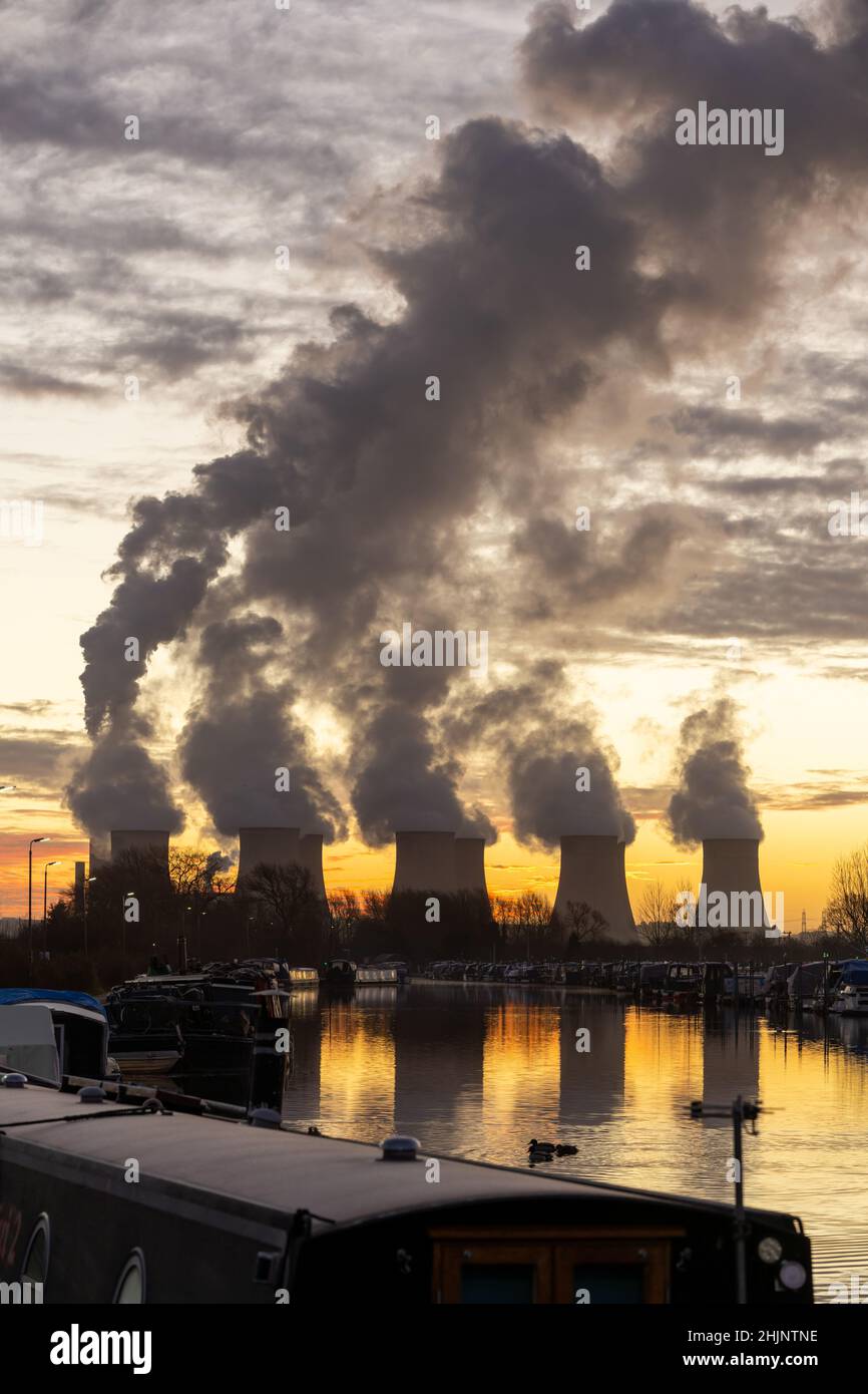 Beautiful dawn sunrise coal fired power station cooling towers smoke plumes into sky. Global warming electricity generation stunning reflection river Stock Photo