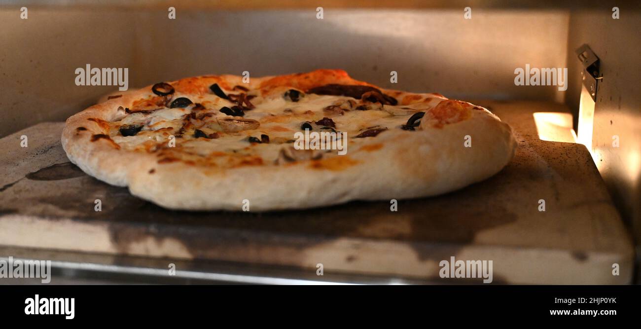 pizza cooking in the pizza oven tase fast food Stock Photo