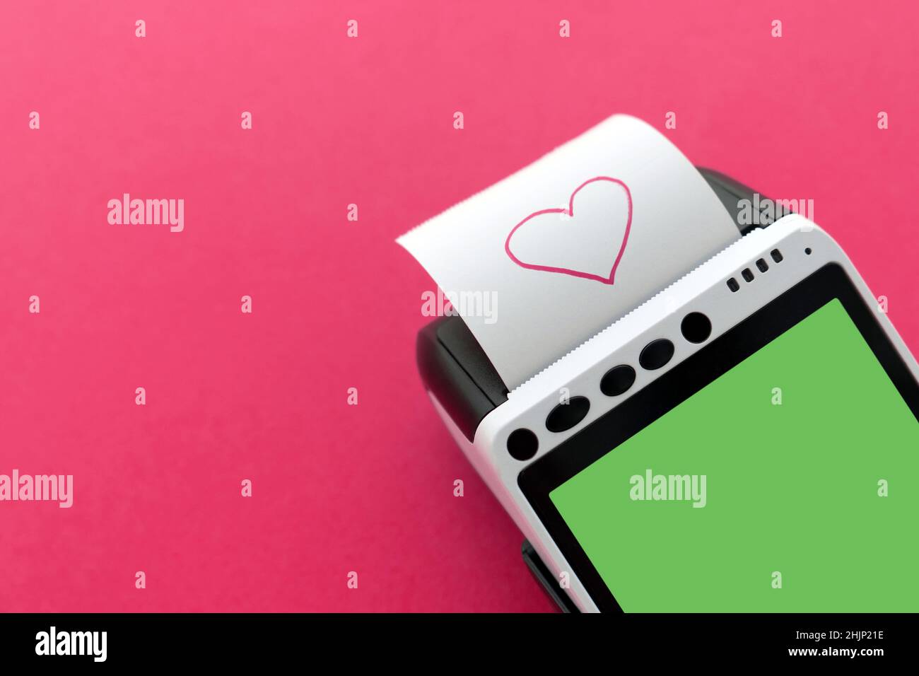 Close-up of credit card POS terminal with printed reciept with a pink heart picture on a pink background with a space for your copy. Happy Valentine's Stock Photo