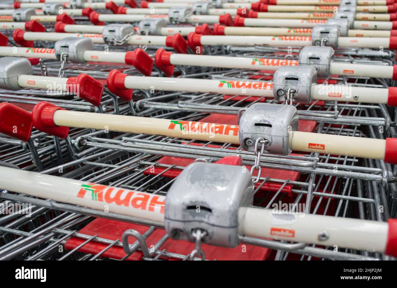 Moscow, Russia, June 2020: Close-up of a coin-operated receiver on the handles of Auchan shopping carts with locks. Stock Photo