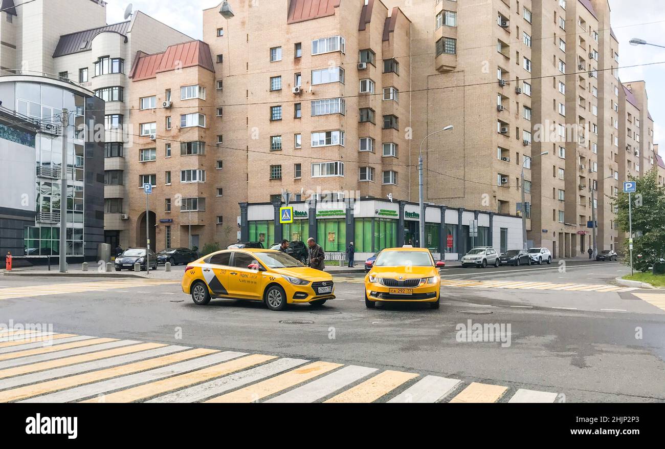 Moscow, Russia, September 2020: Car accident. Two taxi cars crashed at the empty crossroad. Drivers talk to each other near their cars. Stock Photo