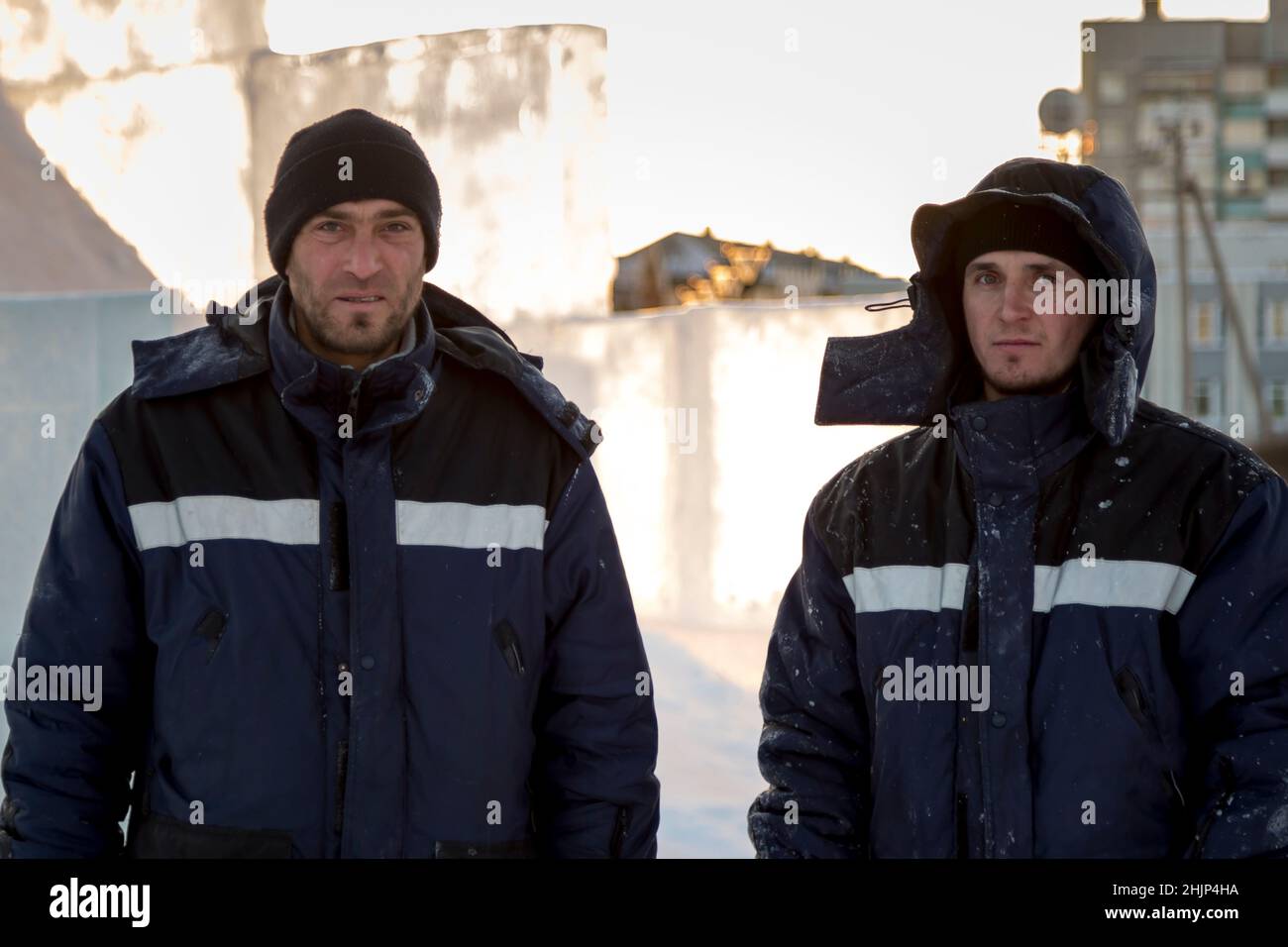 Portrait of two installers at the construction site of the ice town