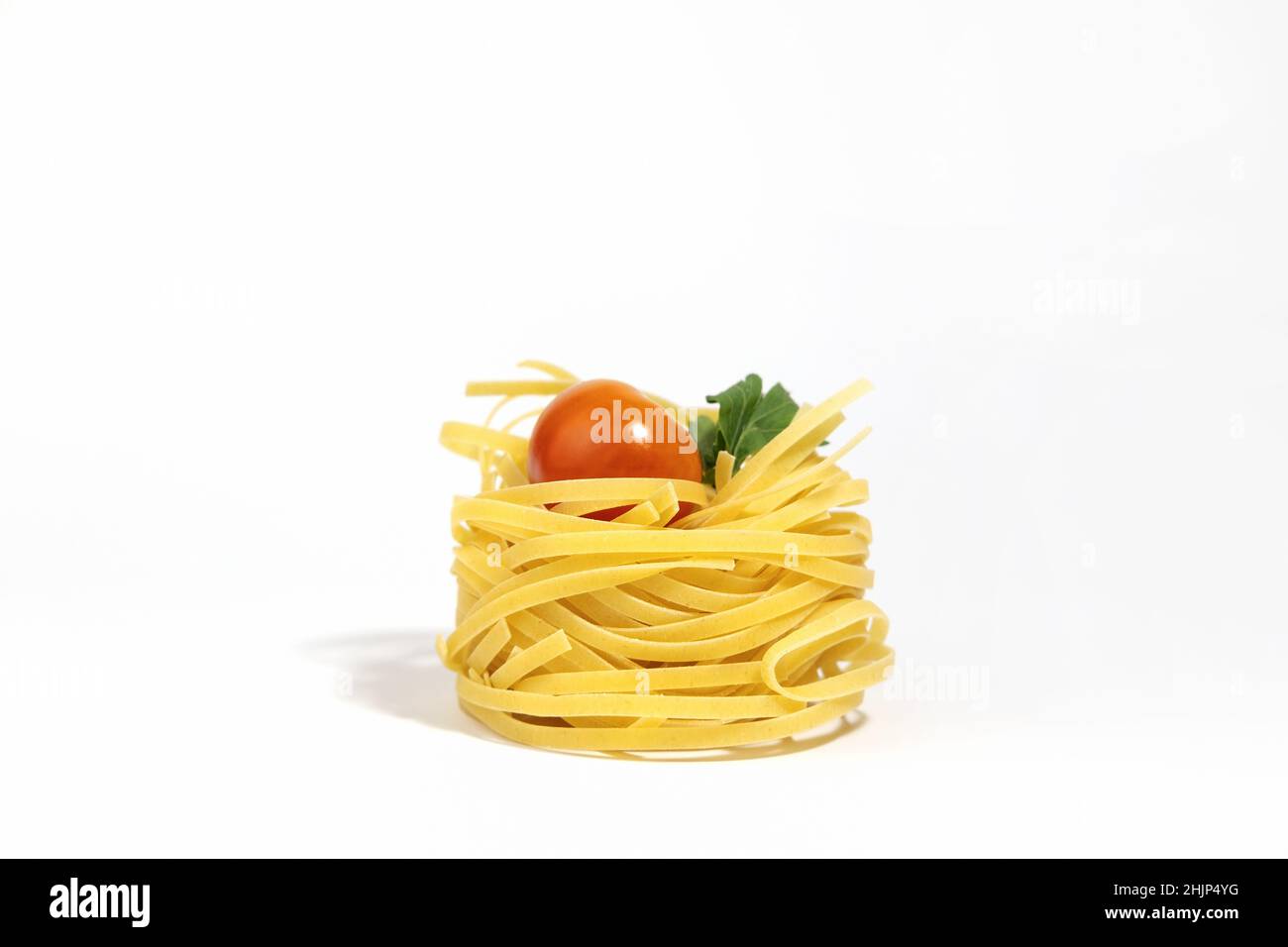 Italian pasta. Spaghetti Capellini, with cherry tomatoes and greens, isolated on a white