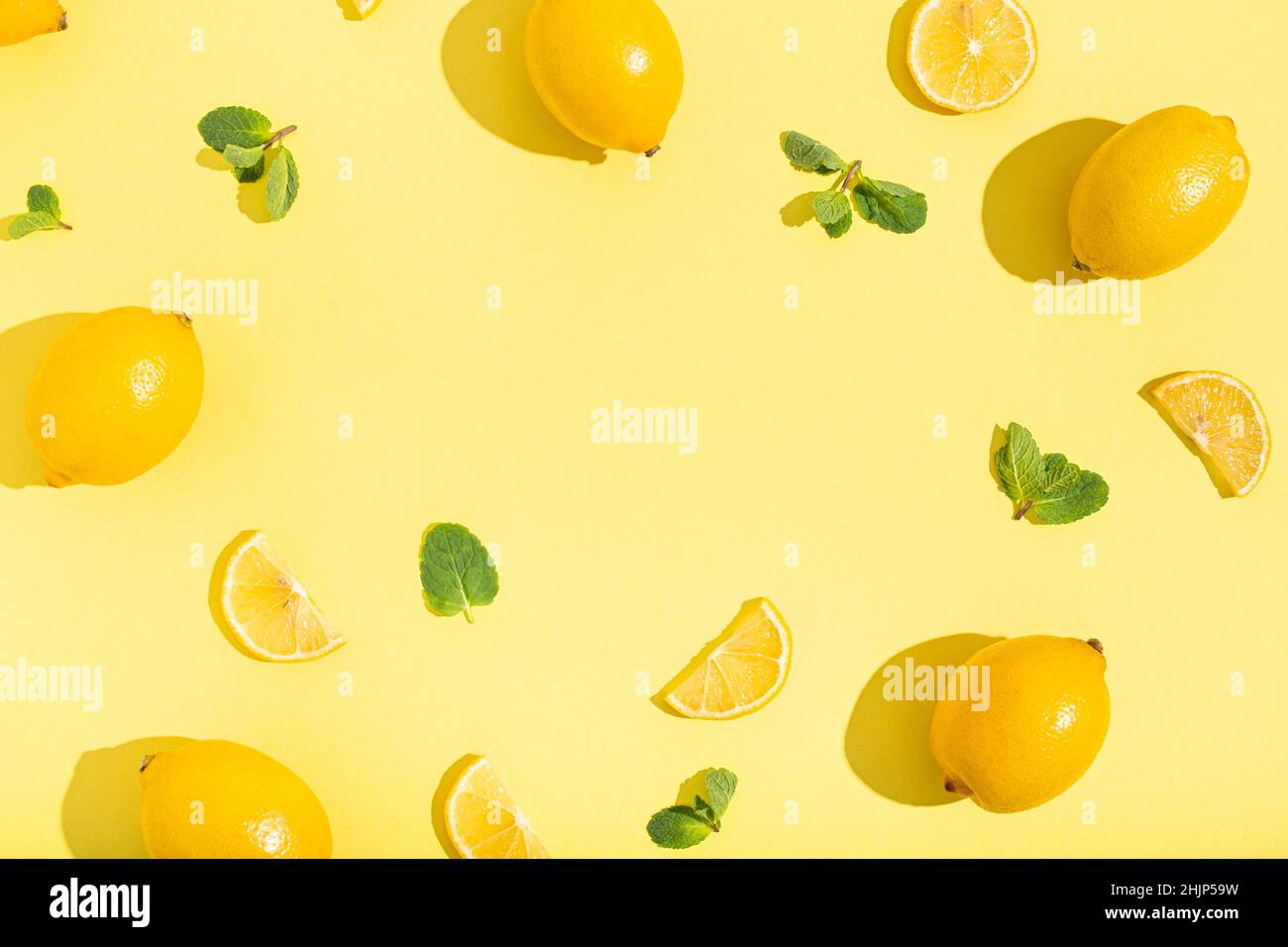 lemons with mint on minimal beige yellow background on bright sun light with hard shadows pattern Stock Photo