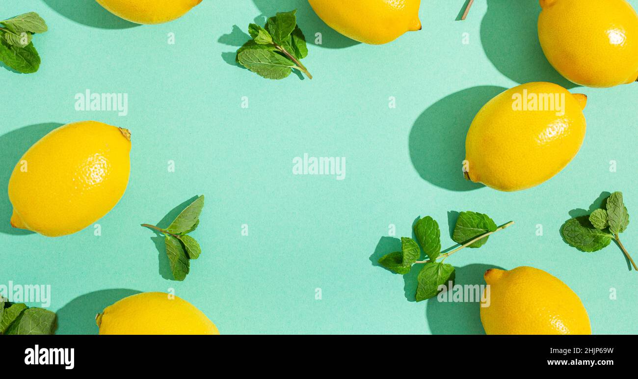 Lemons with mint on minimal blue background sun light hard shadows pattern background Stock Photo