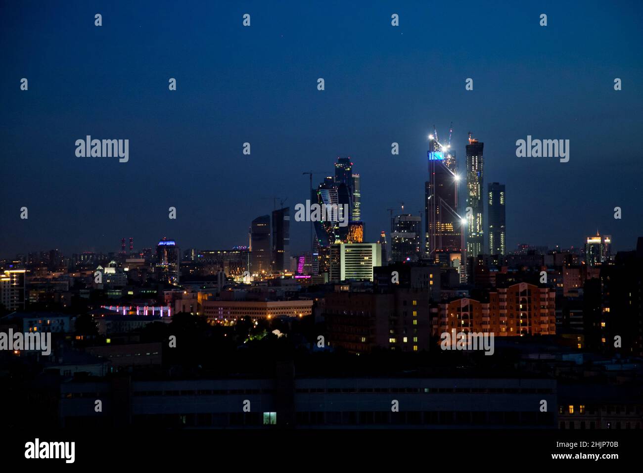 Evening (night) illuminated towers of Moscow City.  Buildings construction on deep blue sky. Panoramic photo. Stock Photo
