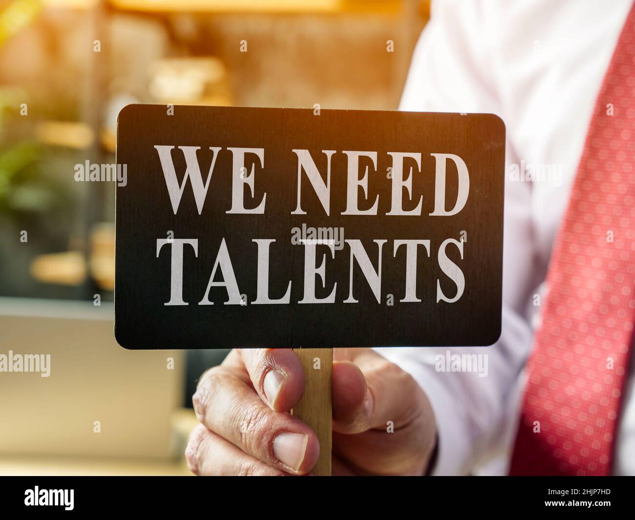 Man shows plate with sign We need talents. Recruitment concept. Stock Photo