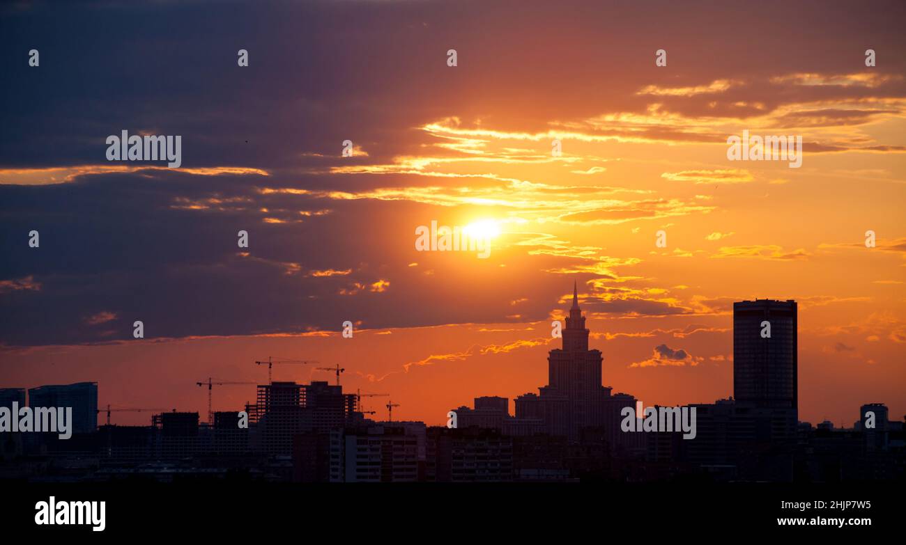 Red and orange sky with clouds and silhouette of cranes and building construction and skyscraper. Moscow. Stock Photo