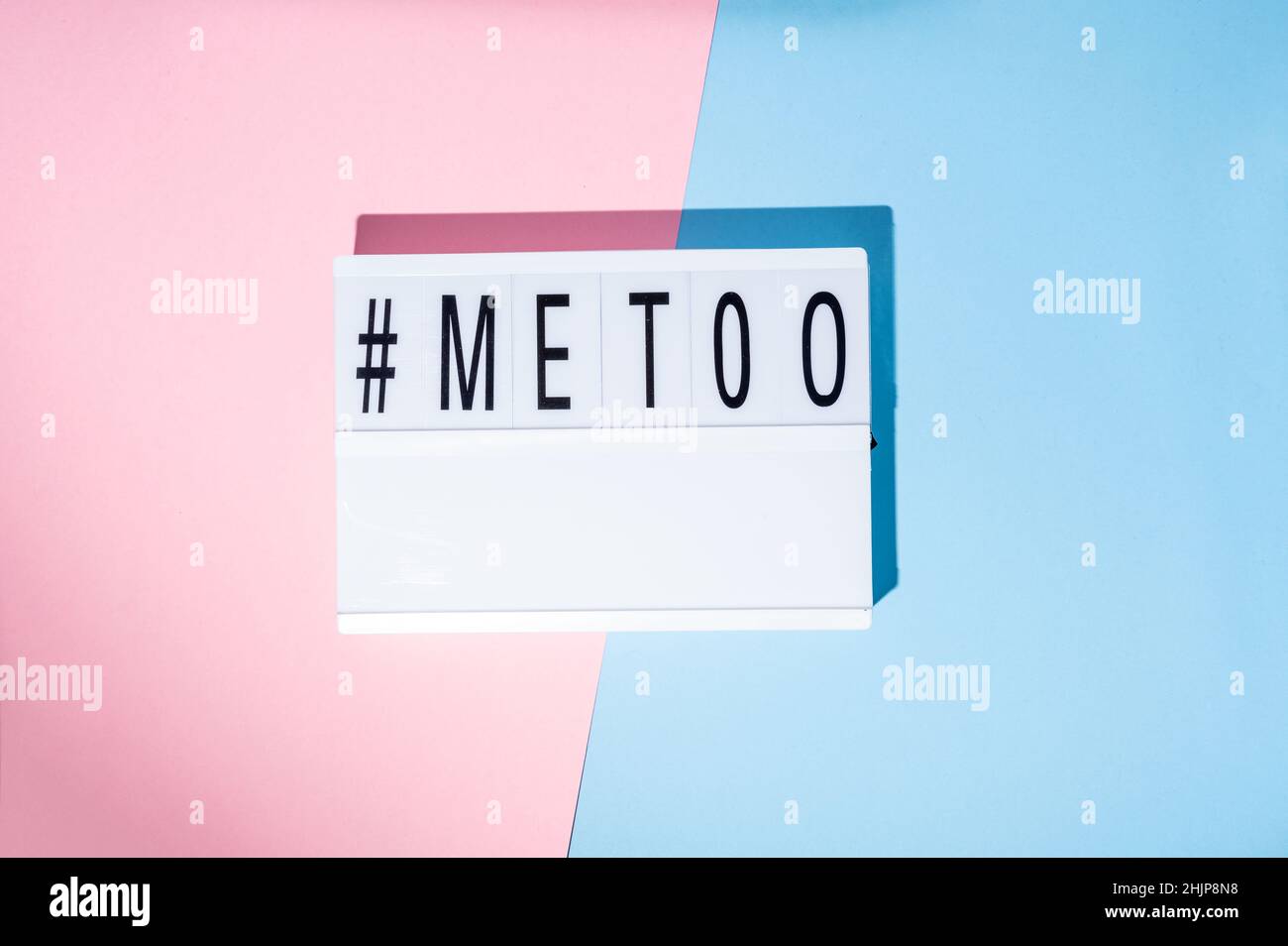 Me too hashtag on the lightbox. Concept of feminism on a blue and pink background. Top view Stock Photo