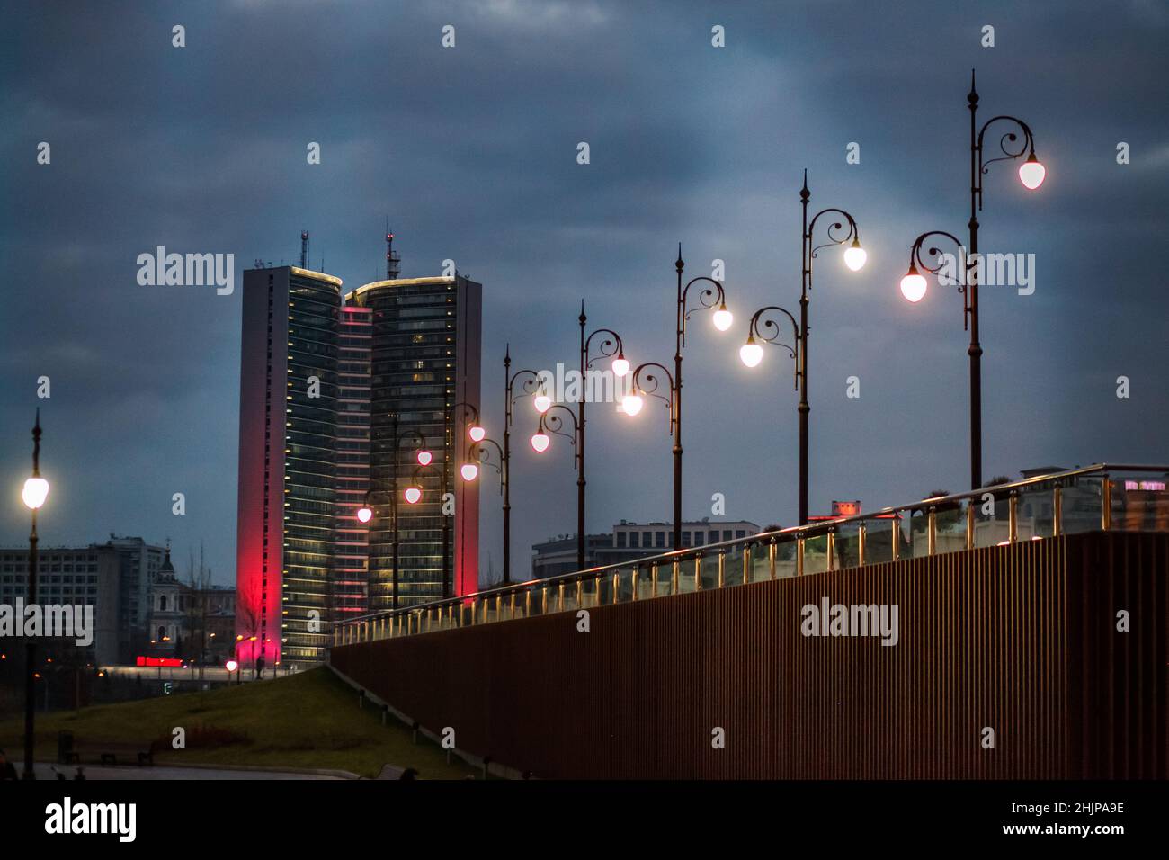 Grey Soviet modernist building with evening illumination and street lightings on grey cloudy sky at dusk. Moscow town Council, as Open Book. Stock Photo