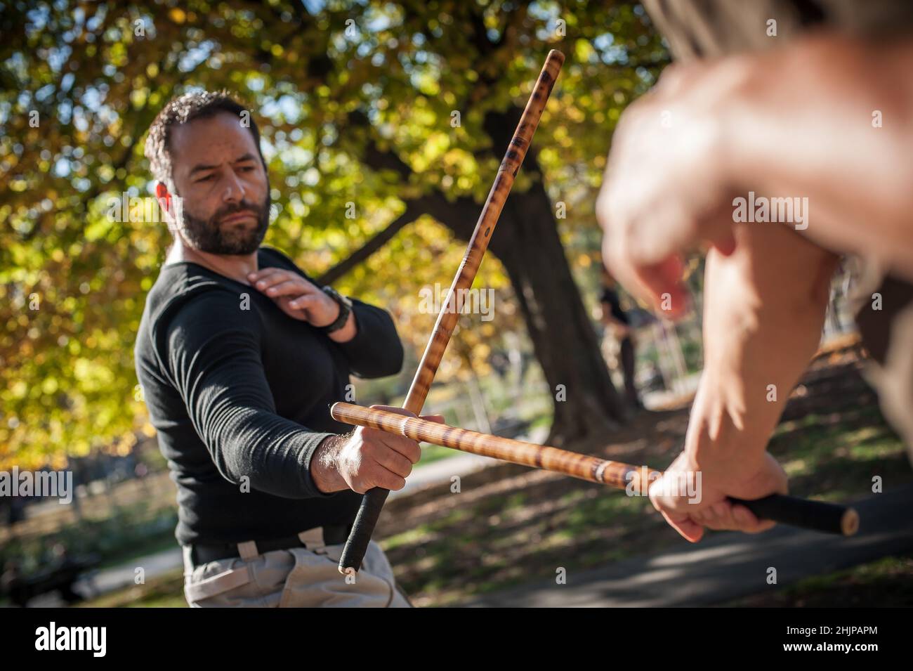 Escrima and kapap instructor demonstrates sticks fighting techniques and  training methods in public park. Filipino Martial Arts. Eskrima. Kali Stock  Photo - Alamy