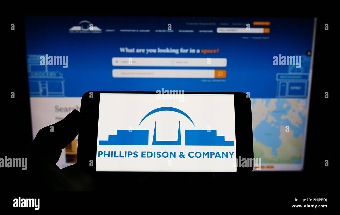 Person holding smartphone with logo of US real estate business Phillips