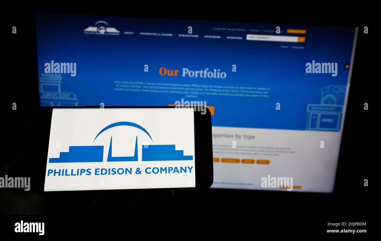 Person holding cellphone with logo of American real estate business