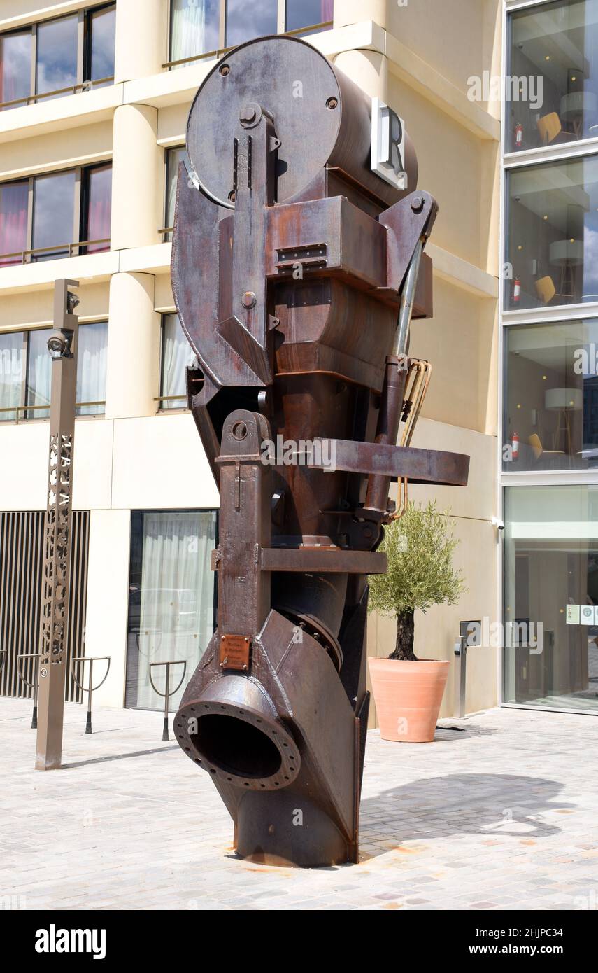 An abstract sculpture made of rusting parts of scrapped ships welded together, in a vaguely humanoid form though, with a circular ‘face’ at the top Stock Photo