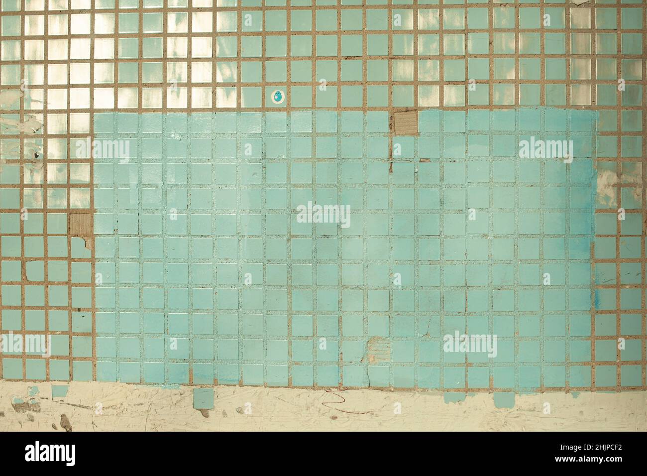 Texture of tile. Wall is in sunlight. Tiles in cladding of building. Small squares. Stock Photo