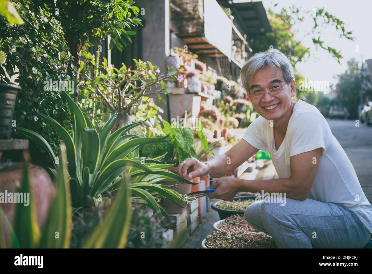 asian senior man relaxing with smiling face at home garden Stock Photo