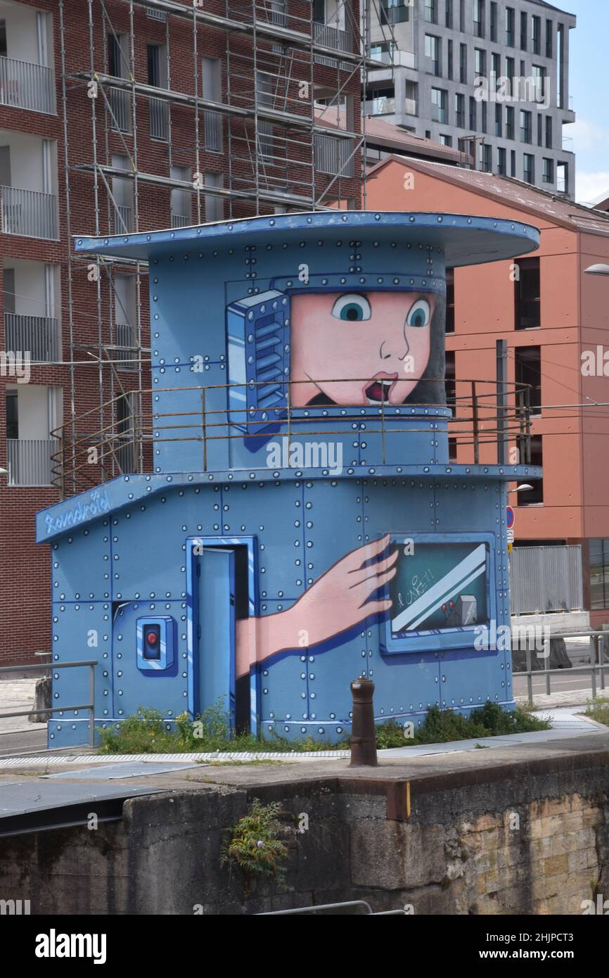 Structure at the entrance to the floating Harbour, Bordeaux, a small two-storey steel structure with a balcony, now disused & painted with a cartoon Stock Photo