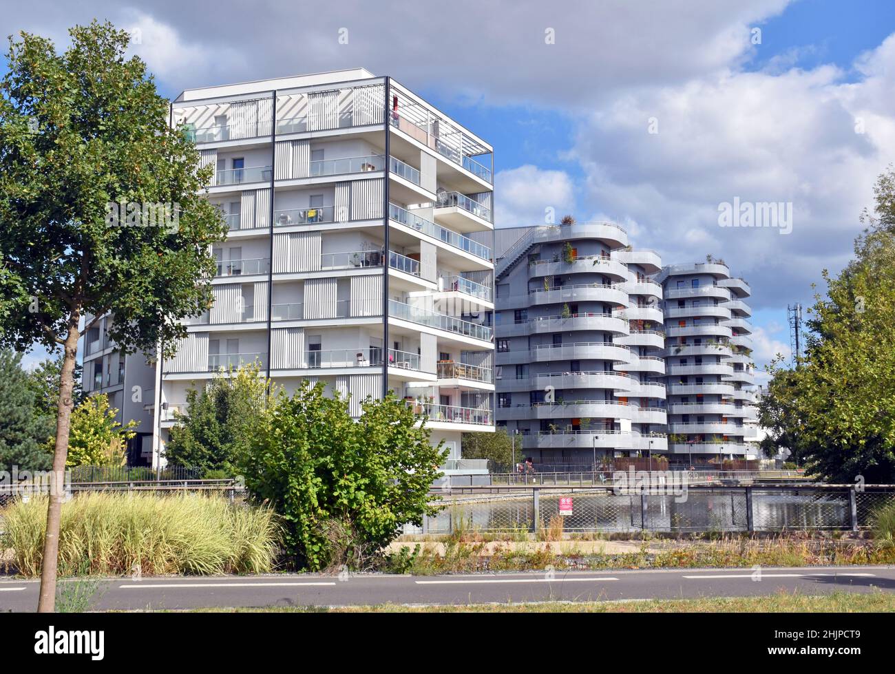 Apartment buildings with generous balconies with views over the canal which drains the area & green belt beyond in the Gingko eco-district, Bordeaux Stock Photo