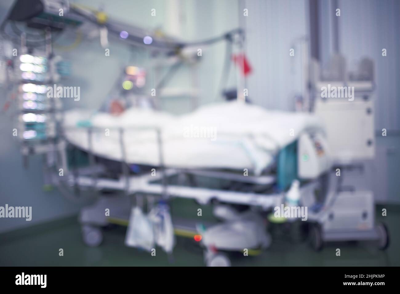 Comatose patient under the clock observation connected to the life-supporting appliance, unfocused background. Stock Photo