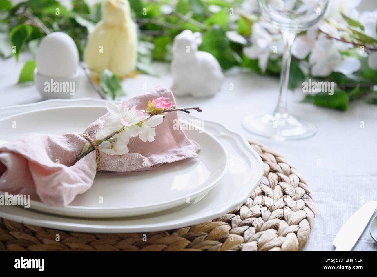 Easter table setting with yellow chick,decorations, fresh flowers and eggs. Elegance dinner. Close up. Stock Photo
