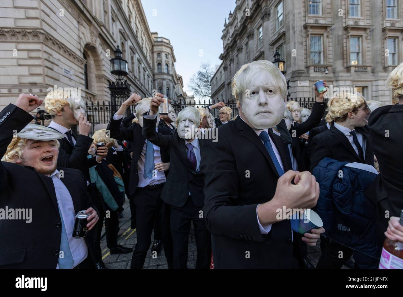 Flash-mob of 'partygate' anti-Boris Johnson protesters wearing floppy blond wigs and Boris Johnson facemasks outside the gates of Downing Street, UK Stock Photo