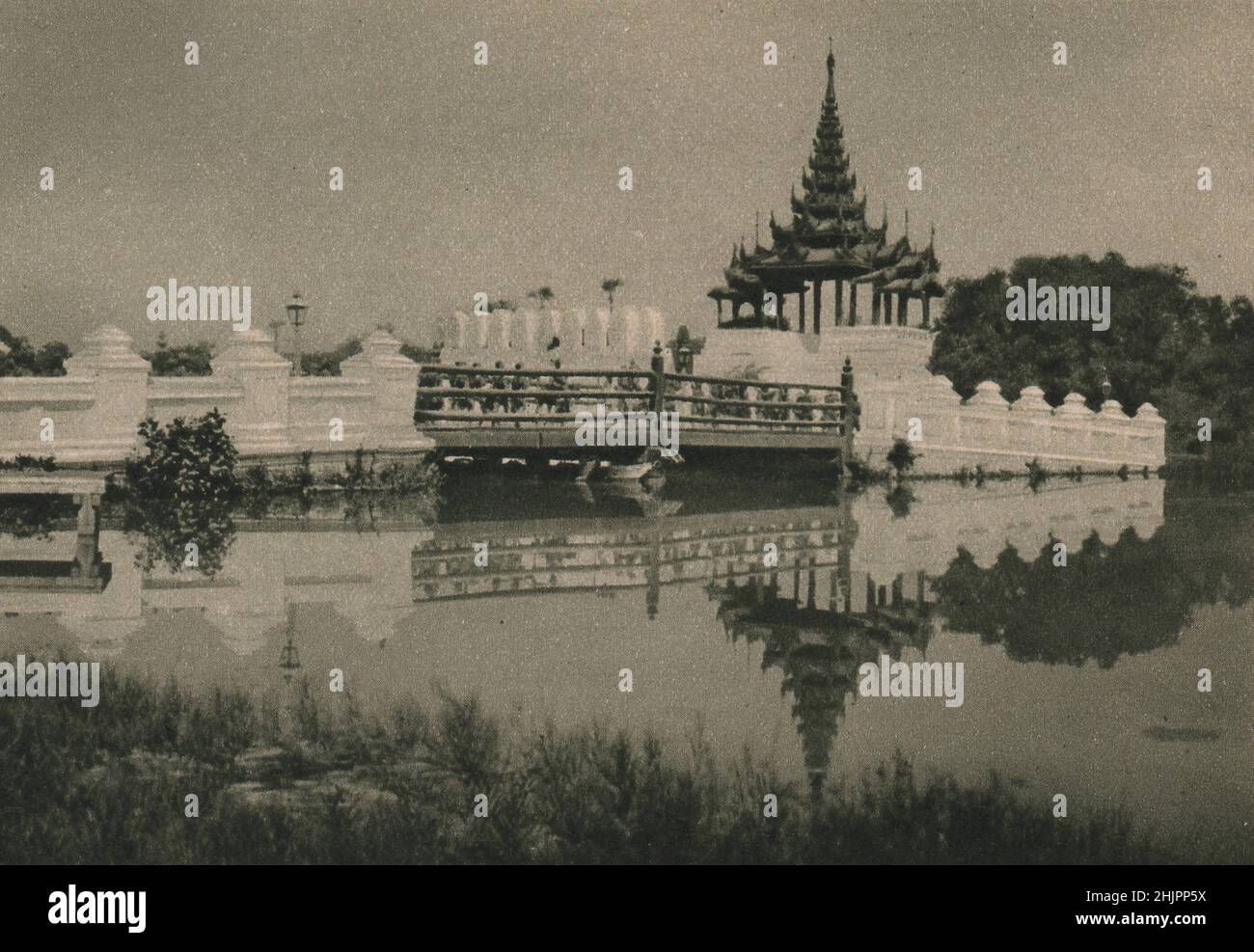 Five graceful bridges across the moat that thus beautifully reflects them give access to Fort Dufferin, the old city of Mandalay. Burma (1923) Stock Photo