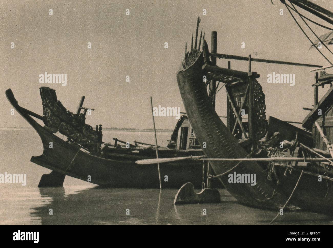 This closer view shows that art the Burmese boat-builder lavishes on the carved steering-chair whence the rudder is guided. Burma (1923) Stock Photo