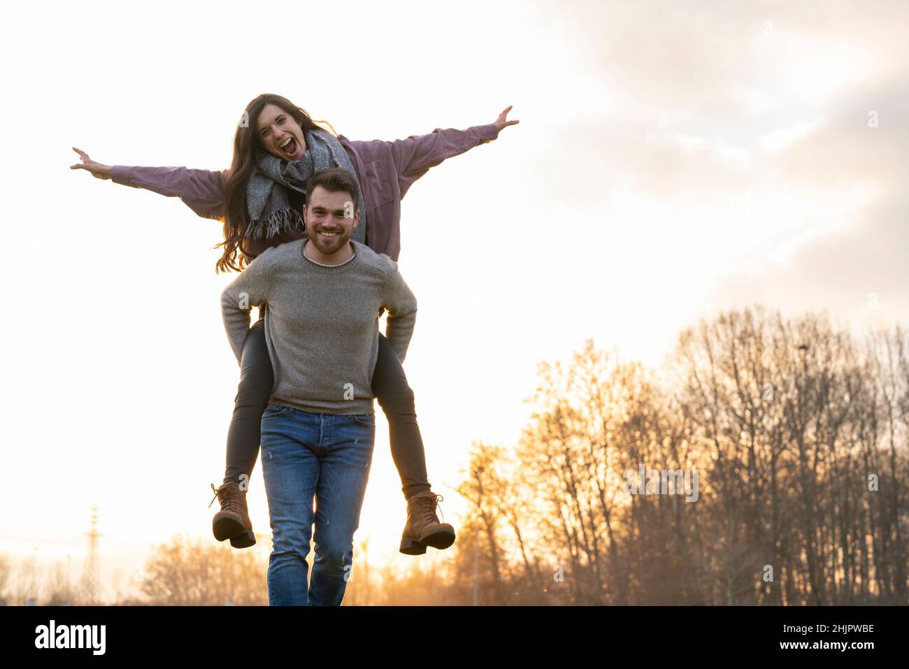 Young heterosexual couple walking and playing in a park on valentine's ...