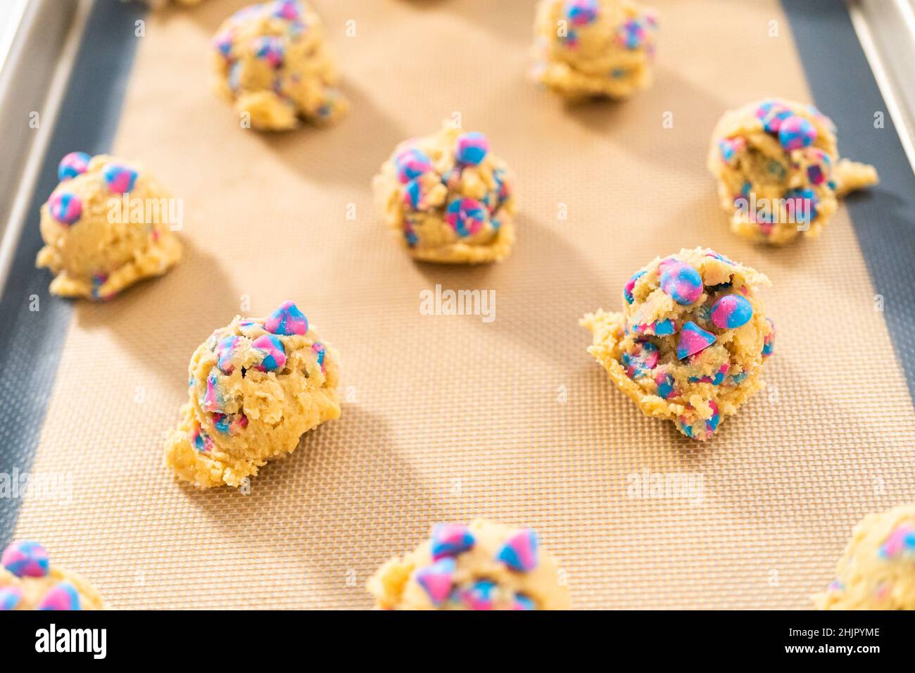 Chilled cookie dough scoops on the baking sheet to bake unicorn