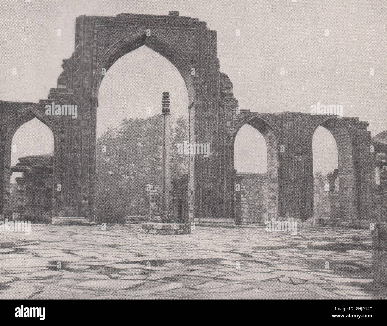 Screen of arches and iron pillar of the kutb sacred ruins. India. Delhi (1923) Stock Photo