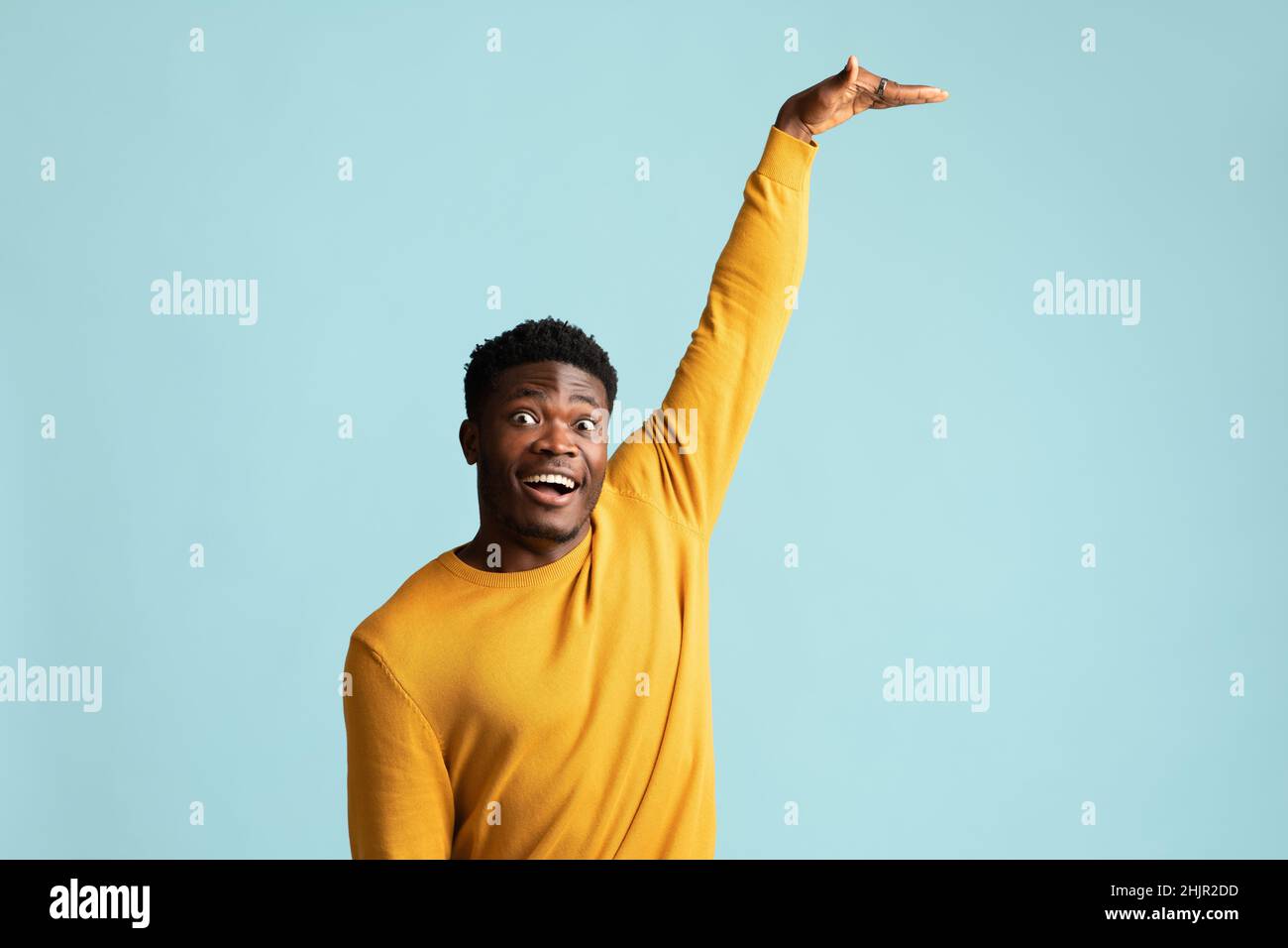 Excited black guy showing height of something Stock Photo
